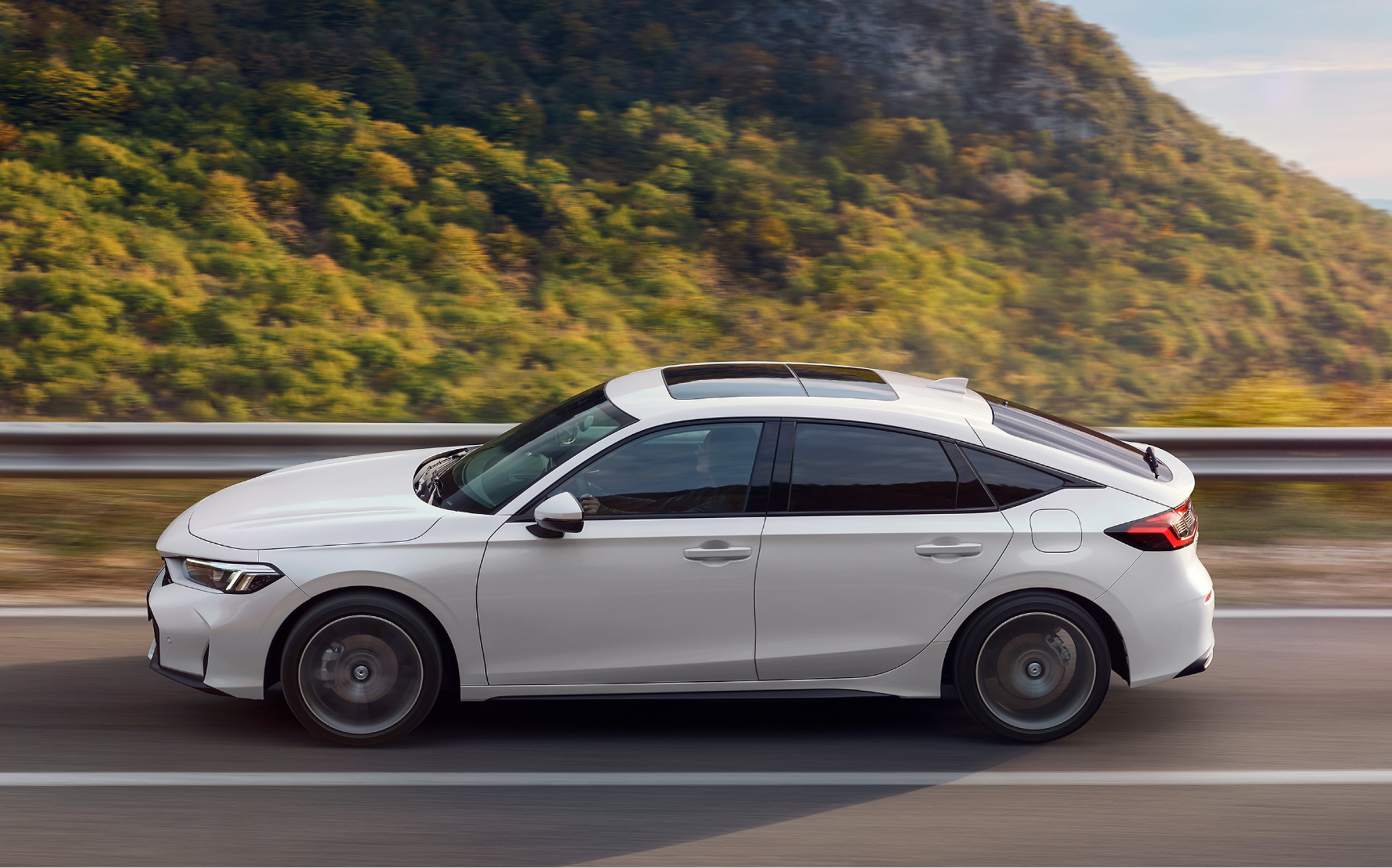 Honda Civic Hybrid kör på motorväg, tagen från sidan.